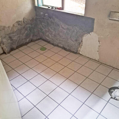 沖縄県北部・今帰仁村の水回りリフォーム後の写真。浴槽とトイレを撤去し、新しい床タイルに張り替えた浴室空間。